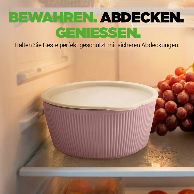 Eine rosafarbene Aufbewahrungsschüssel mit Deckel steht im Kühlschrank neben Trauben.