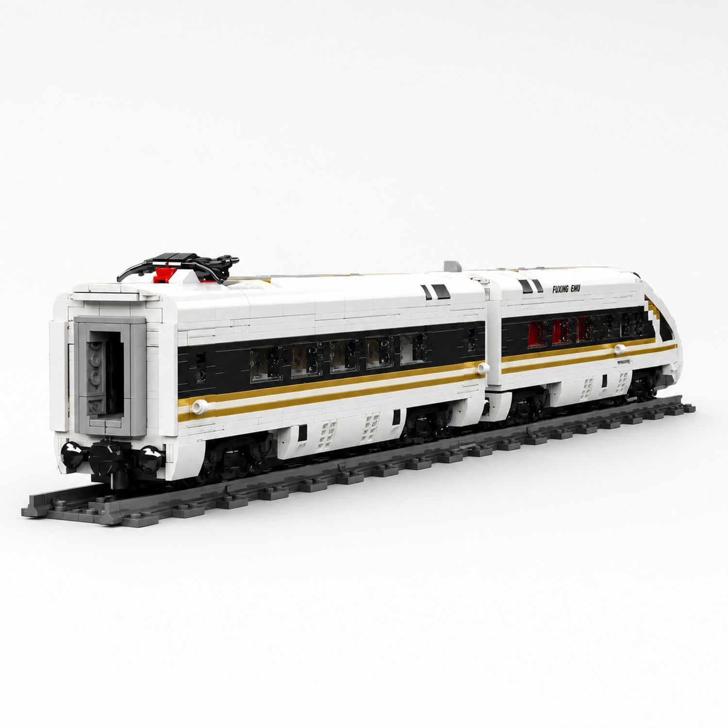 Biały pociąg Lego ze złotymi pasami i czarnymi oknami na torach.