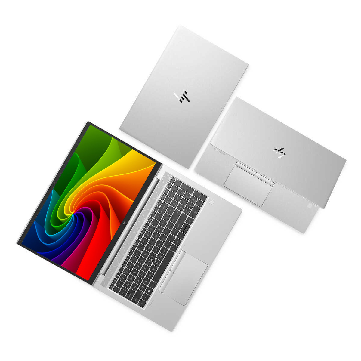 Drei silberne Laptops auf weißem Hintergrund, einer geöffnet mit buntem Bildschirm.