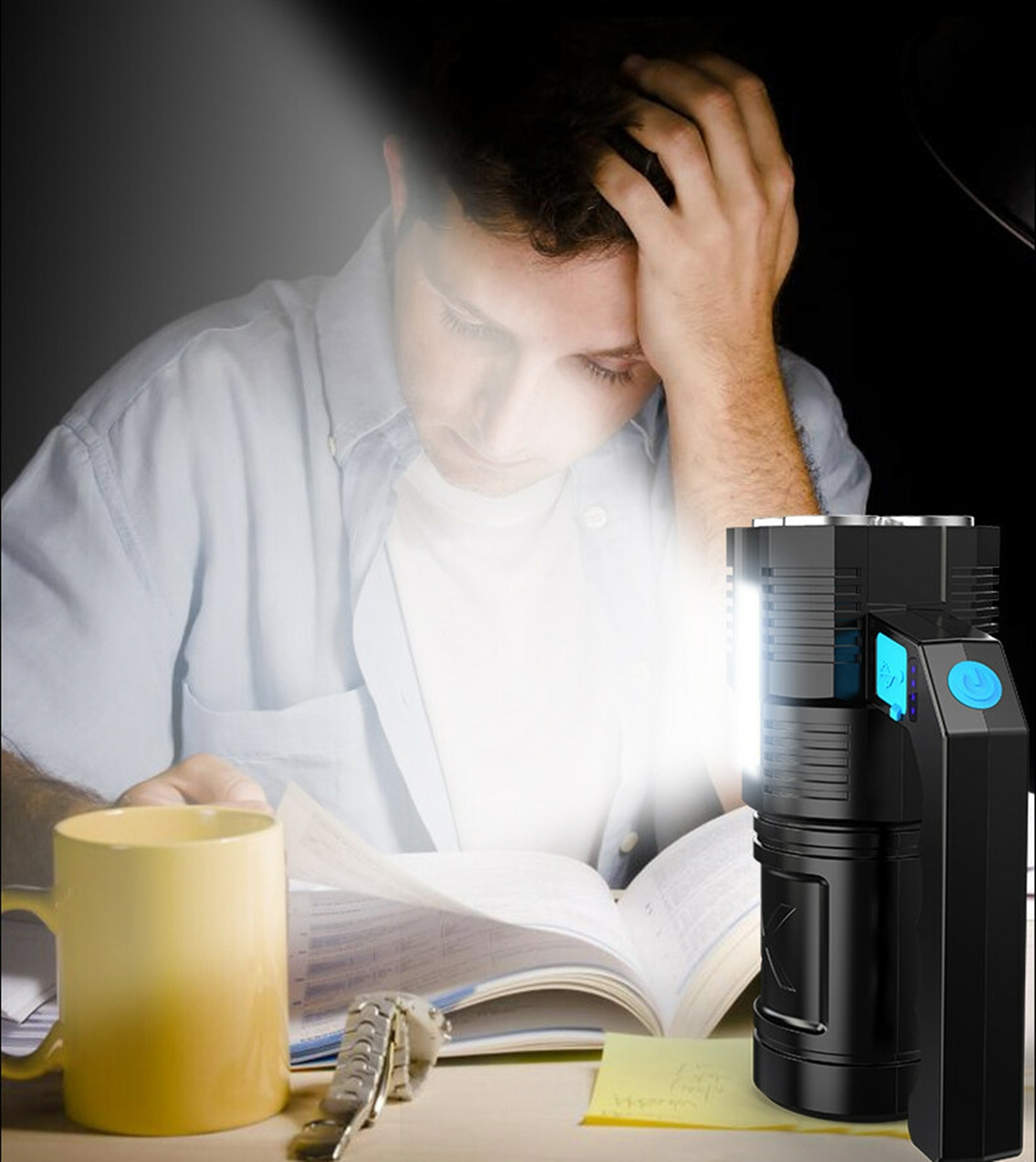 Mann liest bei Nacht, beleuchtet von einer Taschenlampe. Gelbe Tasse, Buch, Schlüssel.