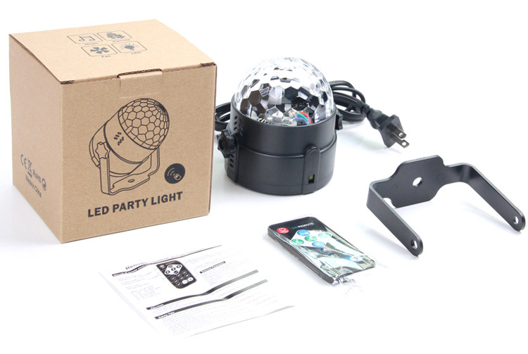 Eine Disco-Kugel-Lampe mit Fernbedienung, Halterung und Anleitung auf weißem Hintergrund.