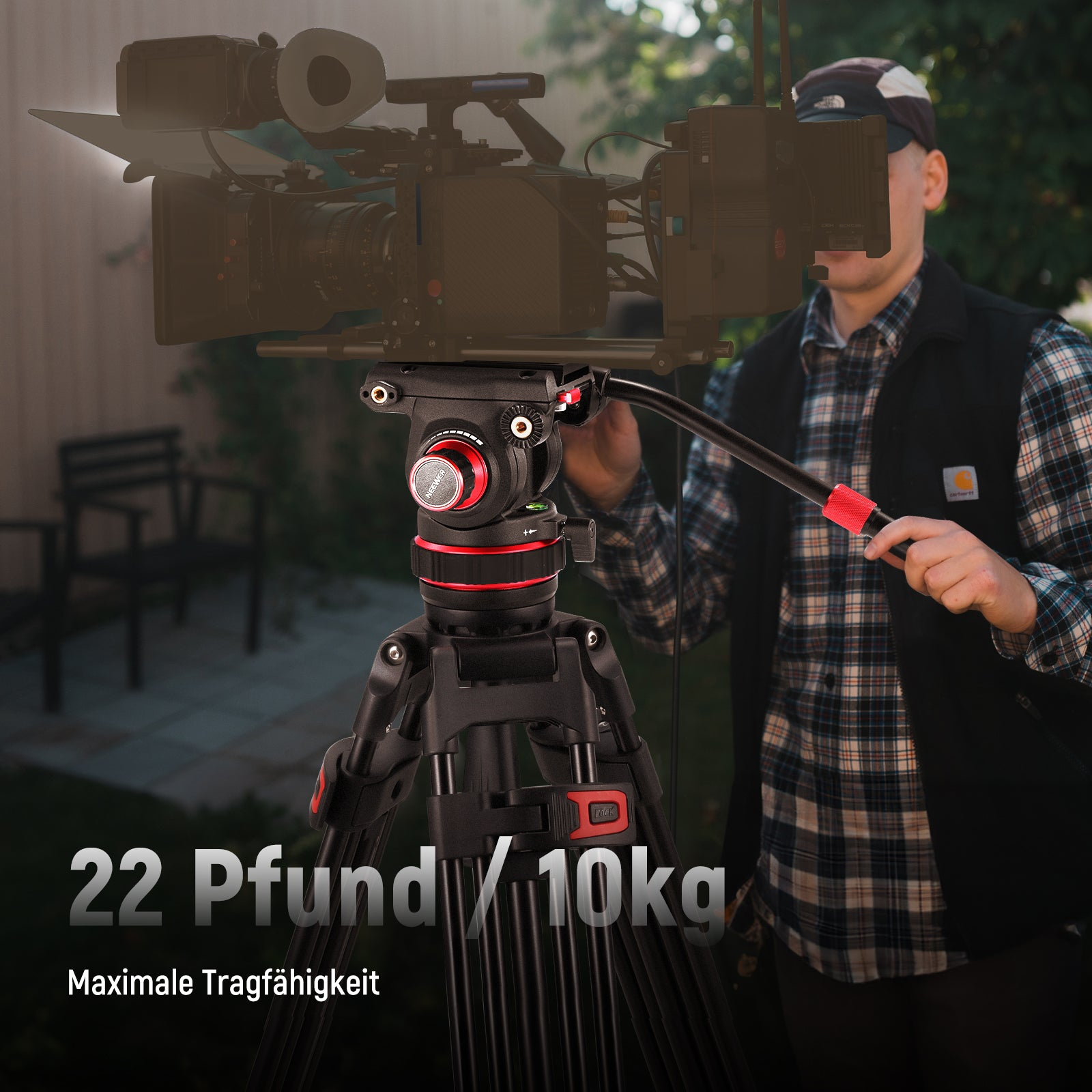 Un uomo regola una telecamera su un treppiede nero con accenti rossi. Carico max 10kg.