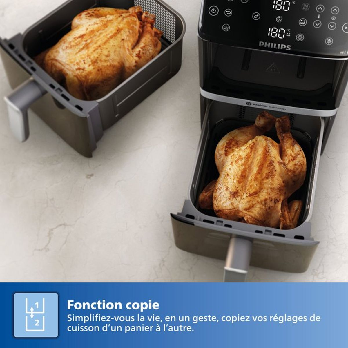 Ein Philips Airfryer mit zwei Brathähnchen, eines im Korb, eines im Gerät.