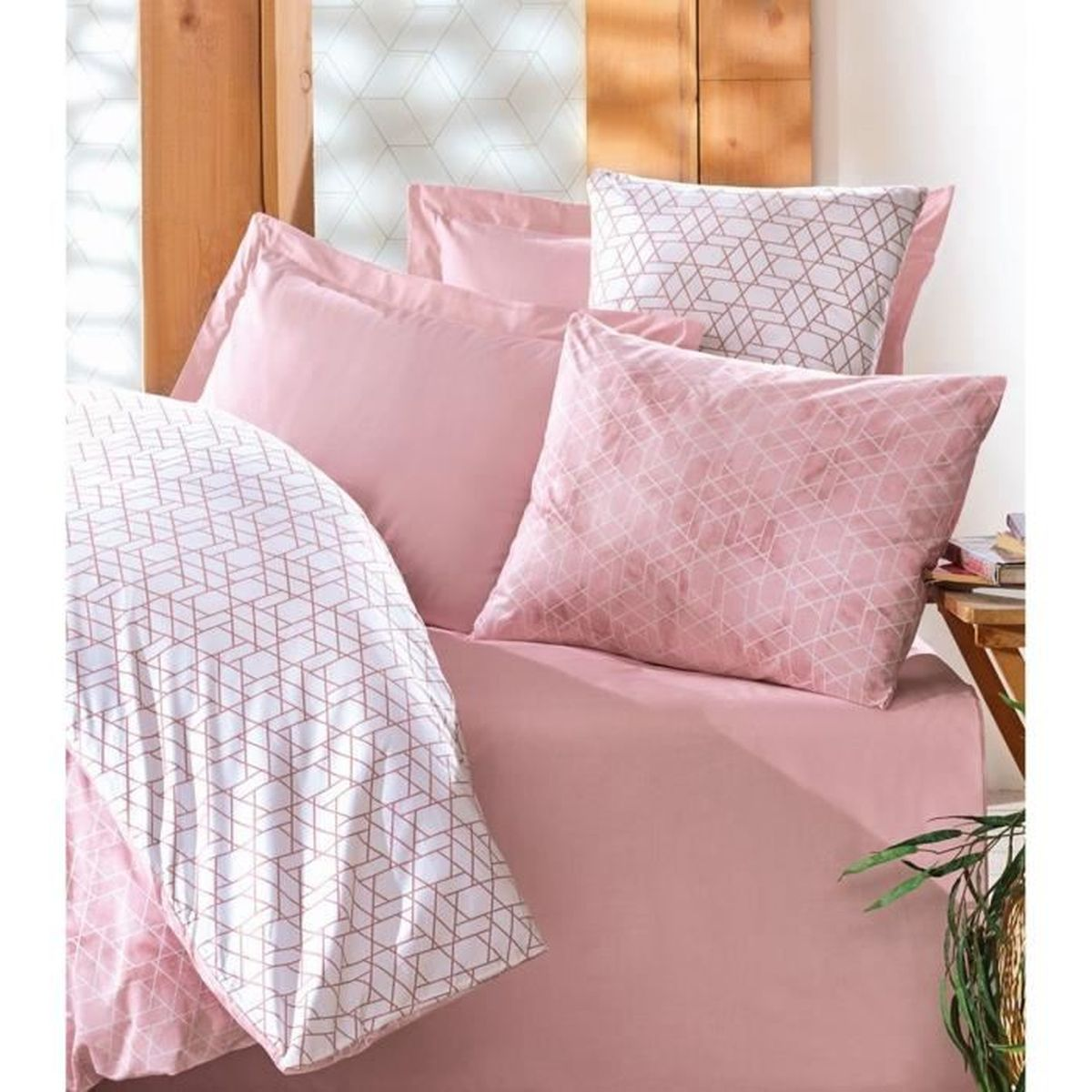 Rosa Bettwäsche mit Kissen mit geometrischem Muster und weißem Bettbezug.