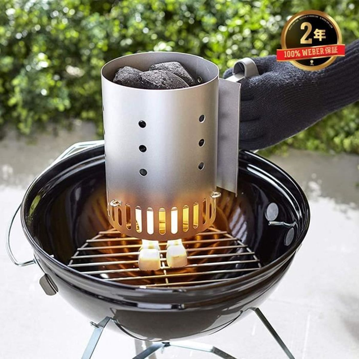 Un encendedor de chimenea de carbón lleno de briquetas se asienta en una rejilla de parrilla, con llamas debajo.