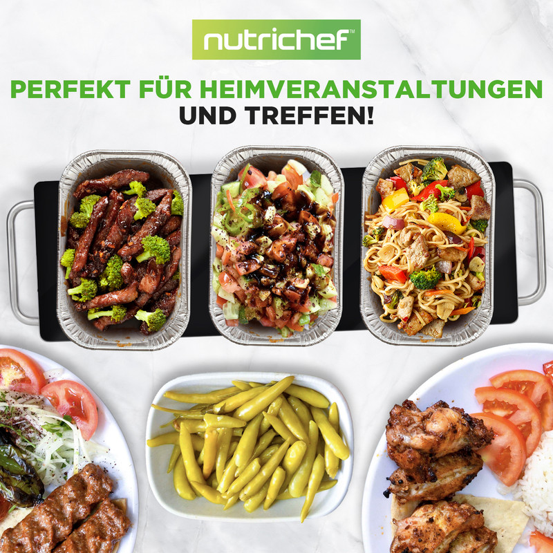 Drei Aluschalen mit Speisen auf einem schwarzen Tablett, daneben Teller mit Essen.