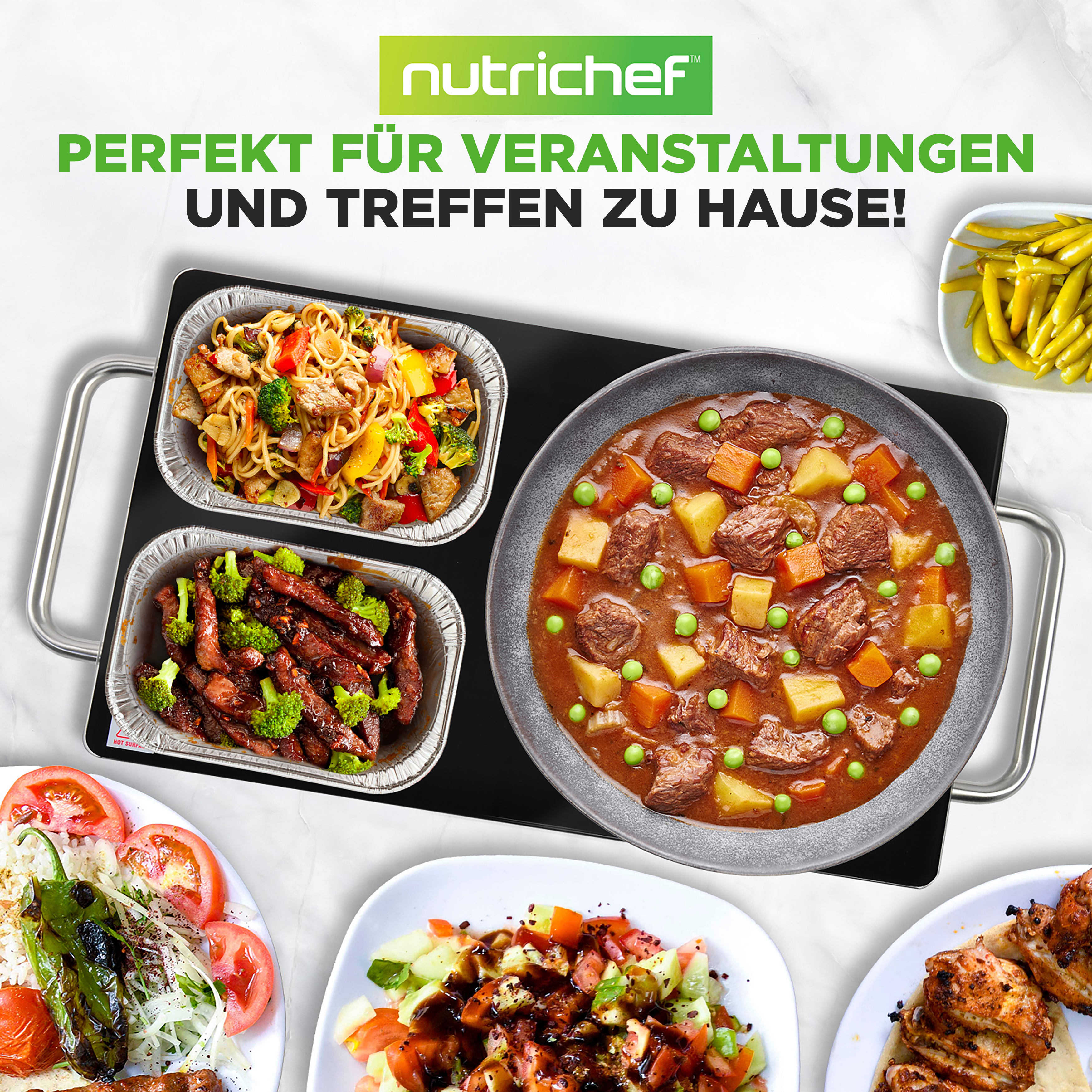 Verschiedene Gerichte auf Marmoroberfläche: Eintopf, Nudeln, Fleisch und Salat.