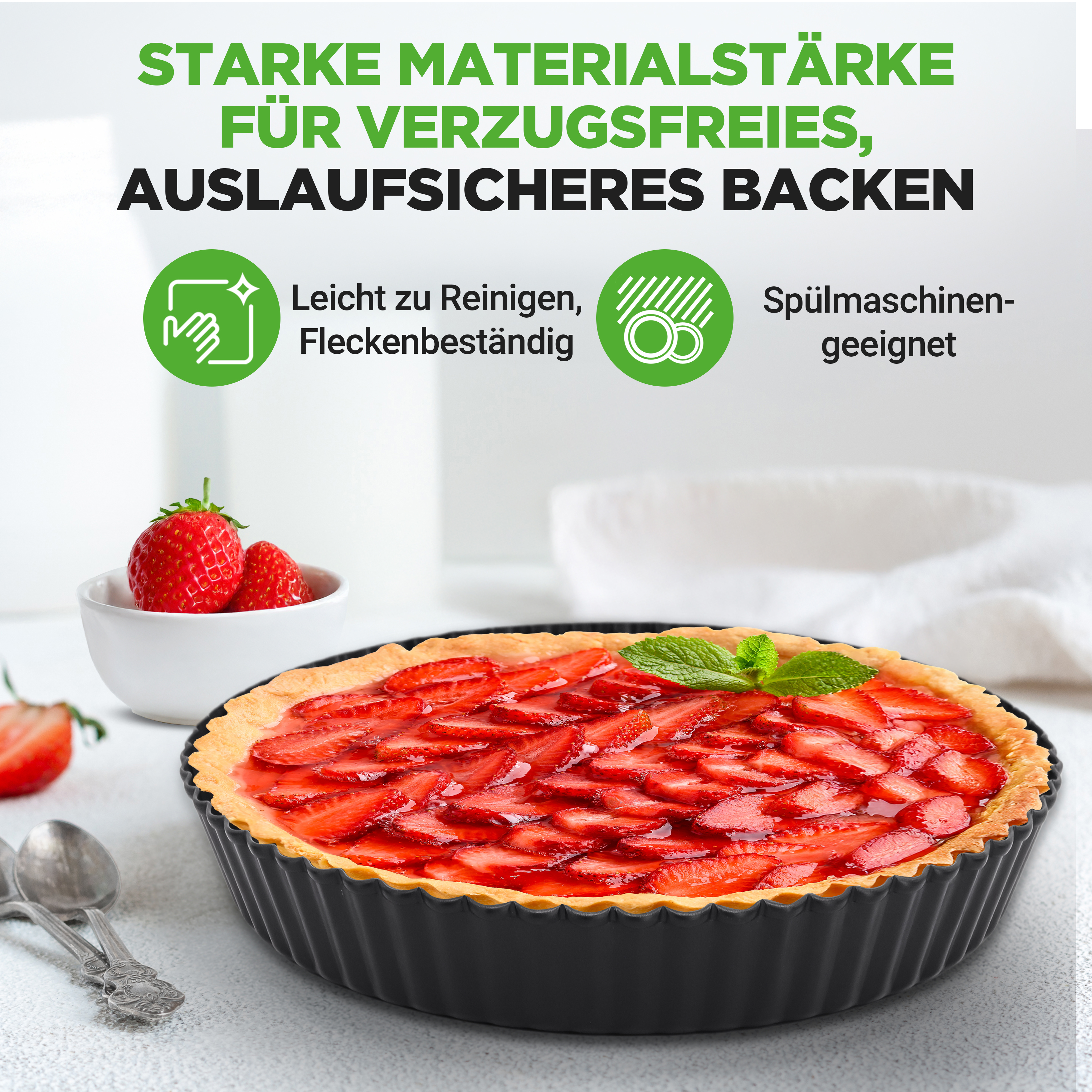 Erdbeertarte in einer schwarzen Backform mit Löffeln und Schüssel voller Erdbeeren daneben.