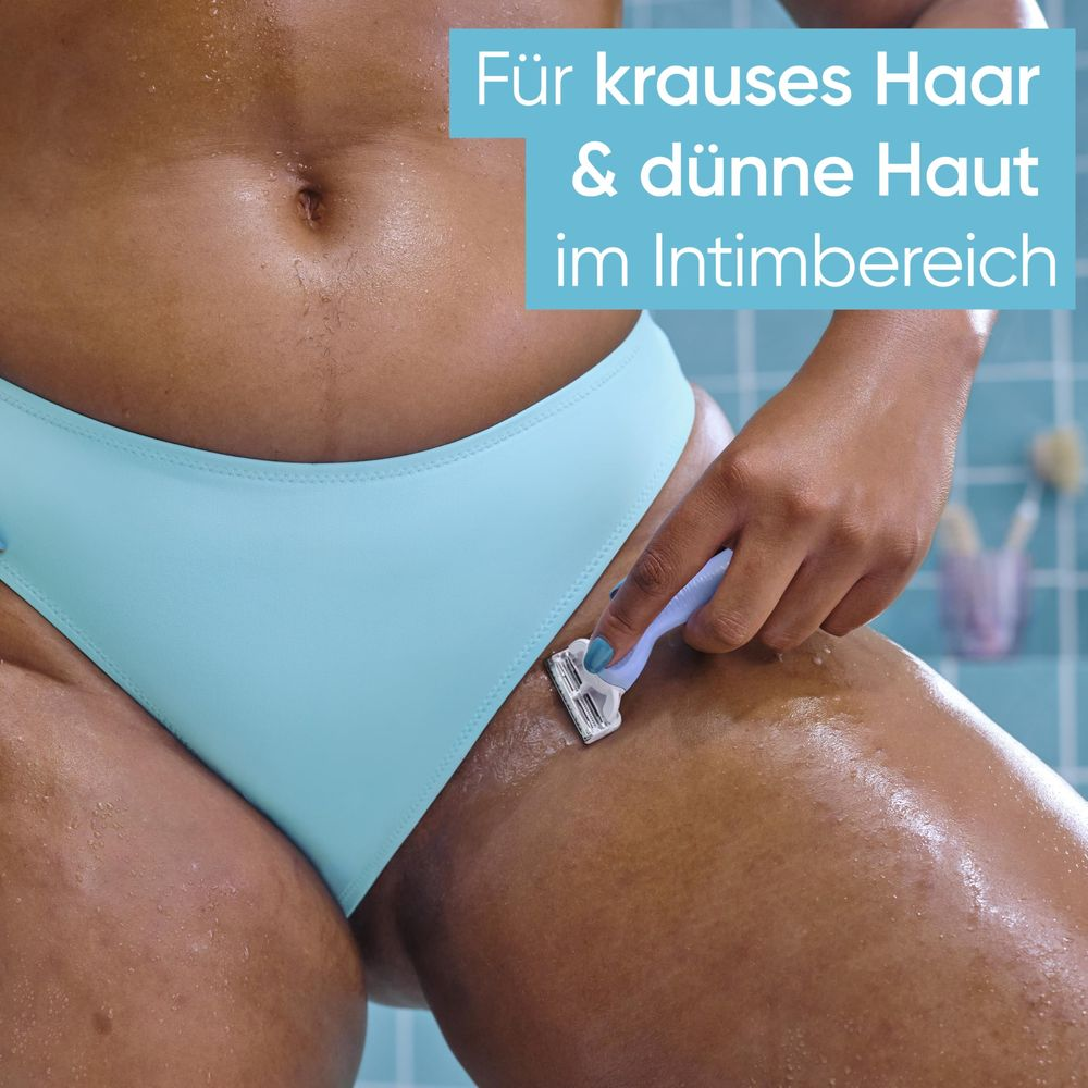 Una persona si rade l'area intima con un rasoio. Mutandine blu.