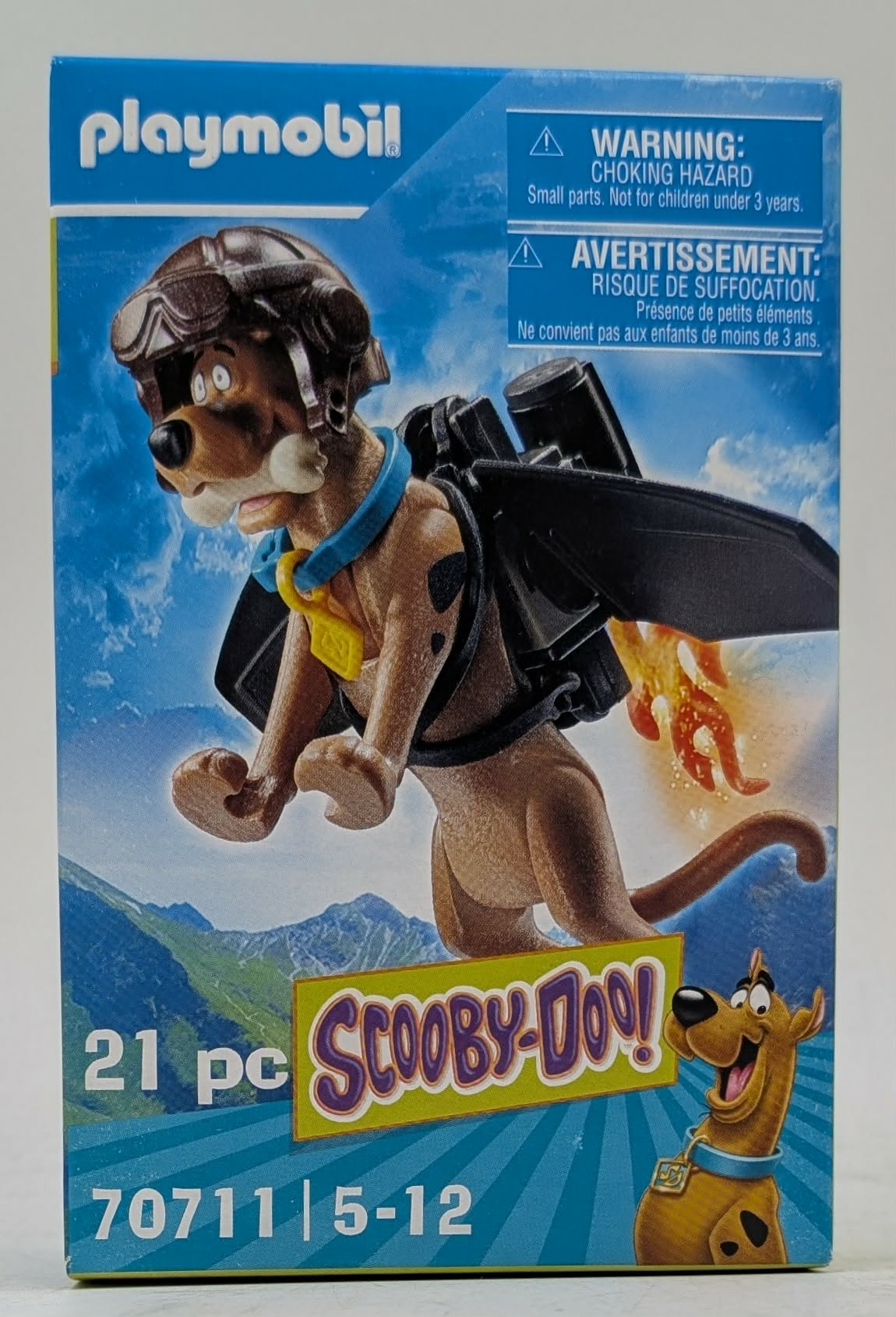 Scatola Playmobil con Scooby-Doo in casco e jetpack che vola sulle montagne.