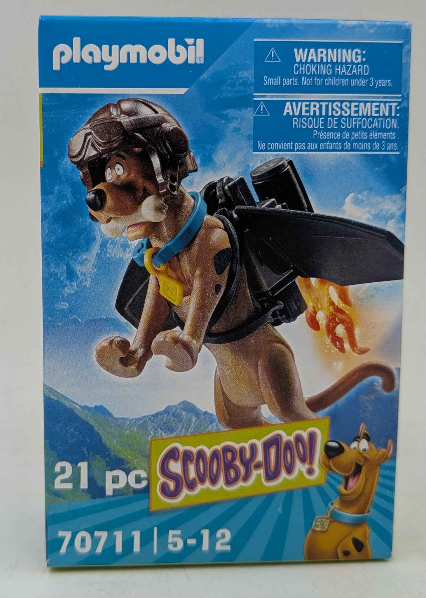Scatola Playmobil Scooby-Doo: Scooby-Doo con jetpack vola, sfondo di montagne.