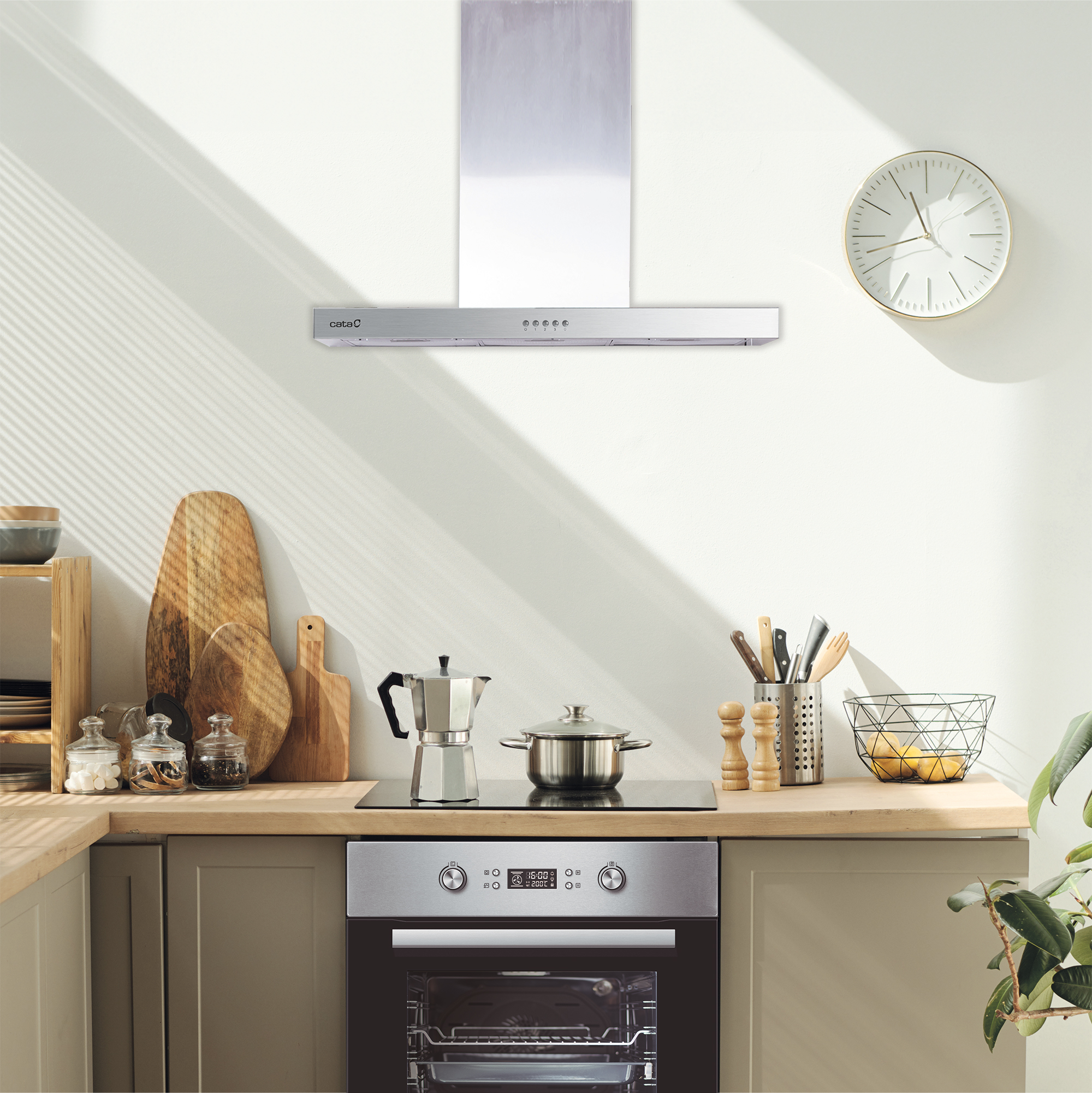 Una cocina moderna con campana extractora, horno y reloj.