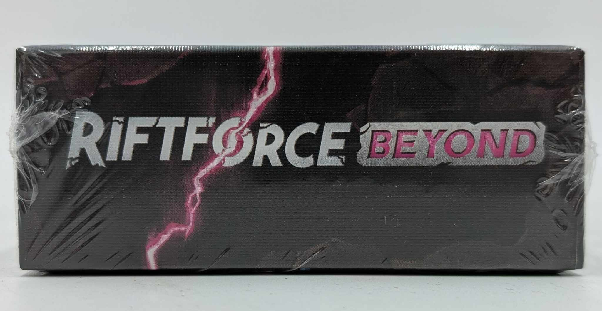Schwarze Box mit "RIFTFORCE BEYOND"-Logo und pinkem Blitz.