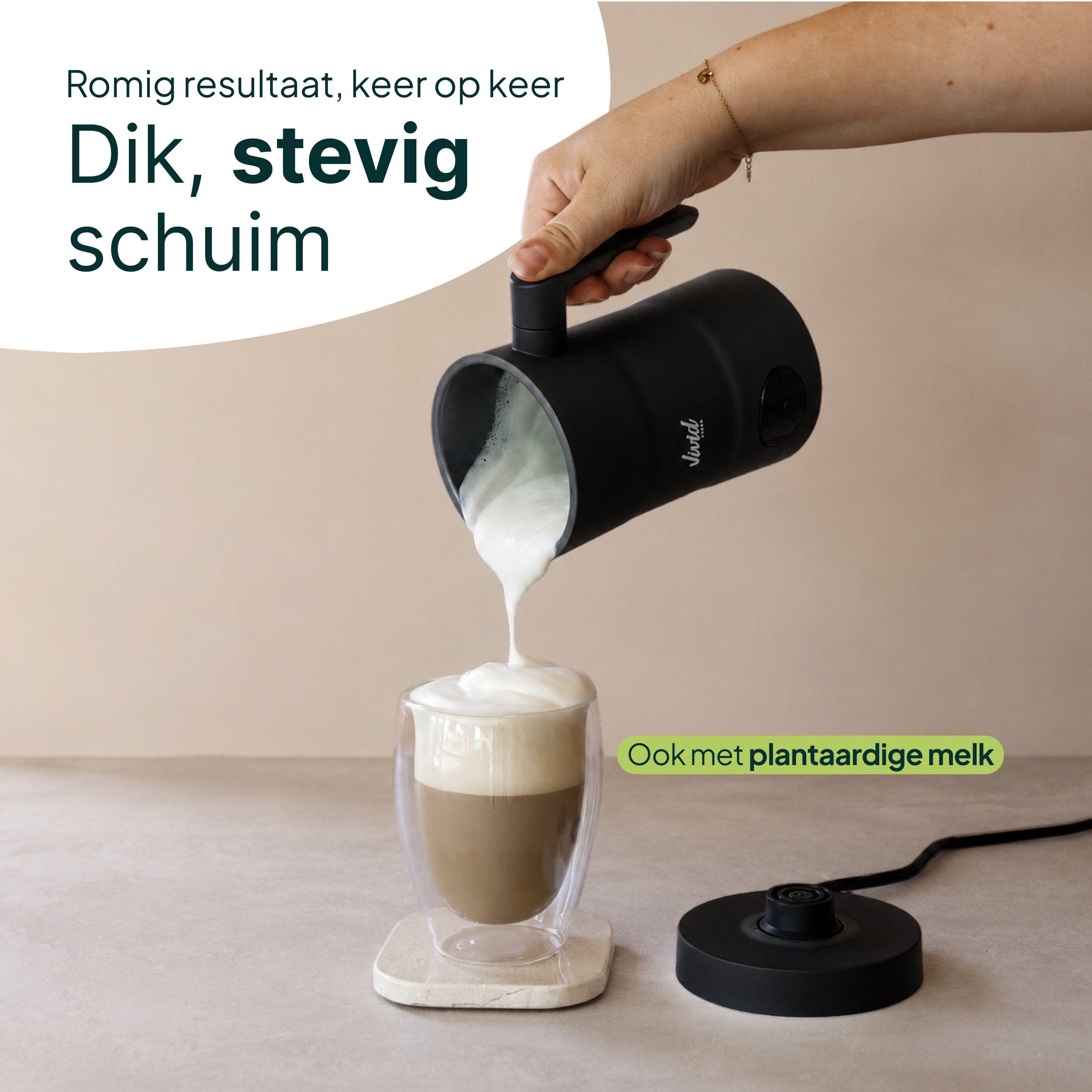 Zwarte melkopschuimer giet romig schuim in een glas koffie.