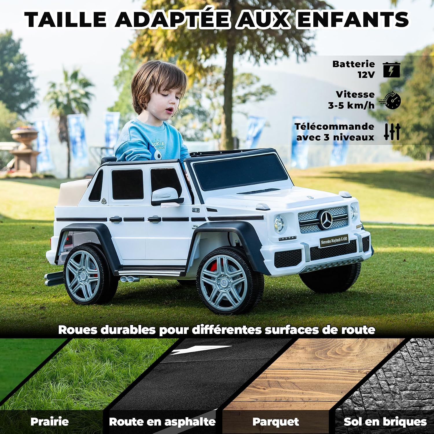 Ein Junge fährt ein weißes Kinder-Mercedes-G-Wagen-Spielzeugauto im Freien auf Gras.