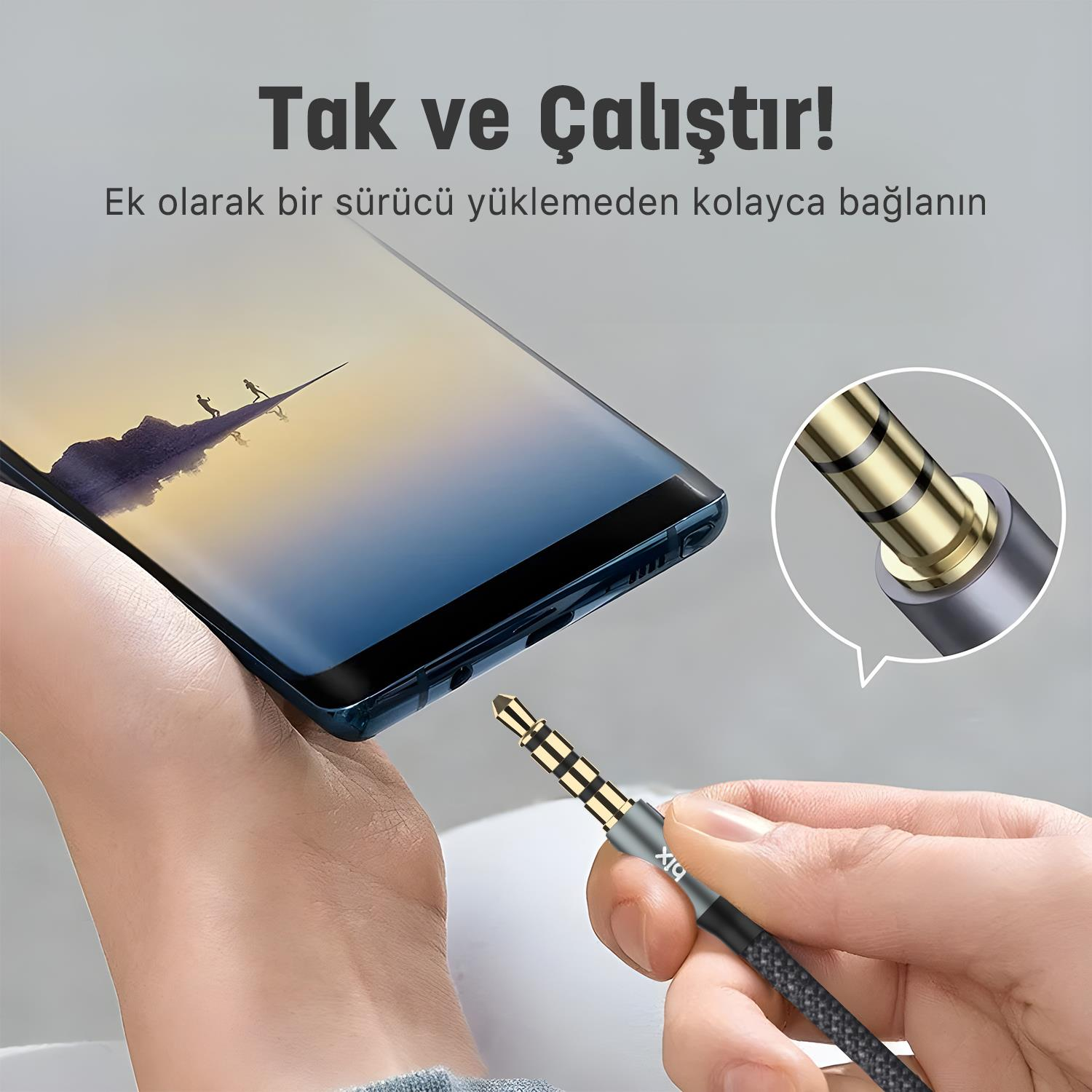 El, akıllı telefona takılan ses kablosunu tutuyor. Fişin yakın çekimi.