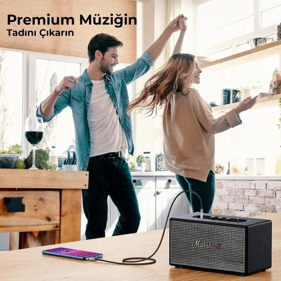 Bir çift, telefona bağlı bir Marshall hoparlörden gelen müzikle mutfakta dans ediyor.