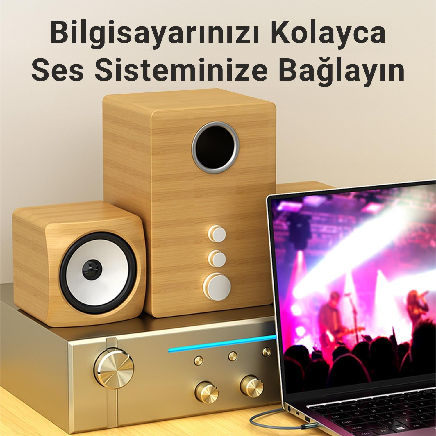 Bir dizüstü bilgisayar, konser gösteren bir amplifikatöre ve hoparlörlere bağlanır.