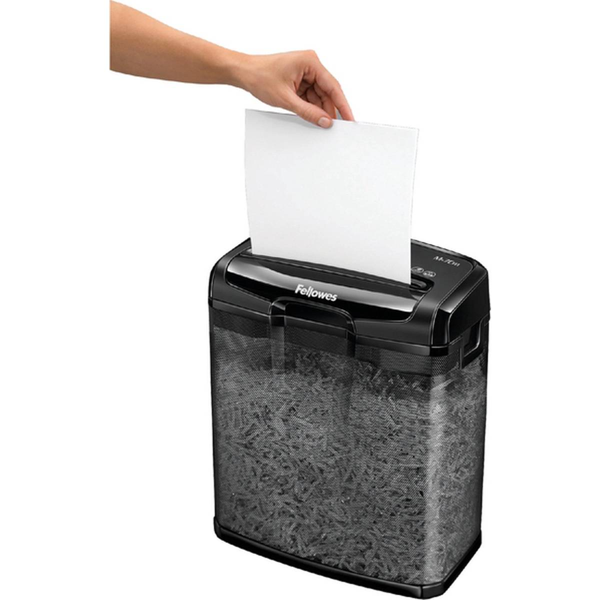 A hand feeds a sheet of paper into a Fellowes shredder filled with shredded paper.