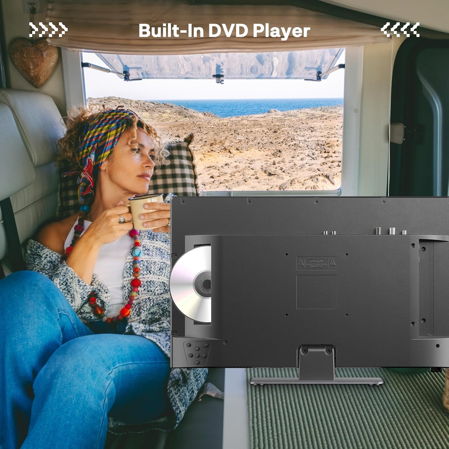 Frau im Wohnmobil trinkt Kaffee, blickt auf Meerblick. Eingebauter DVD-Player sichtbar.