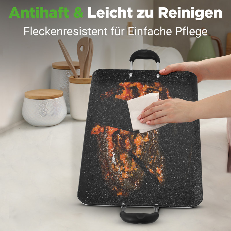 Eine Hand wischt eine Grillplatte mit Essensresten mit einem weißen Papiertuch ab.