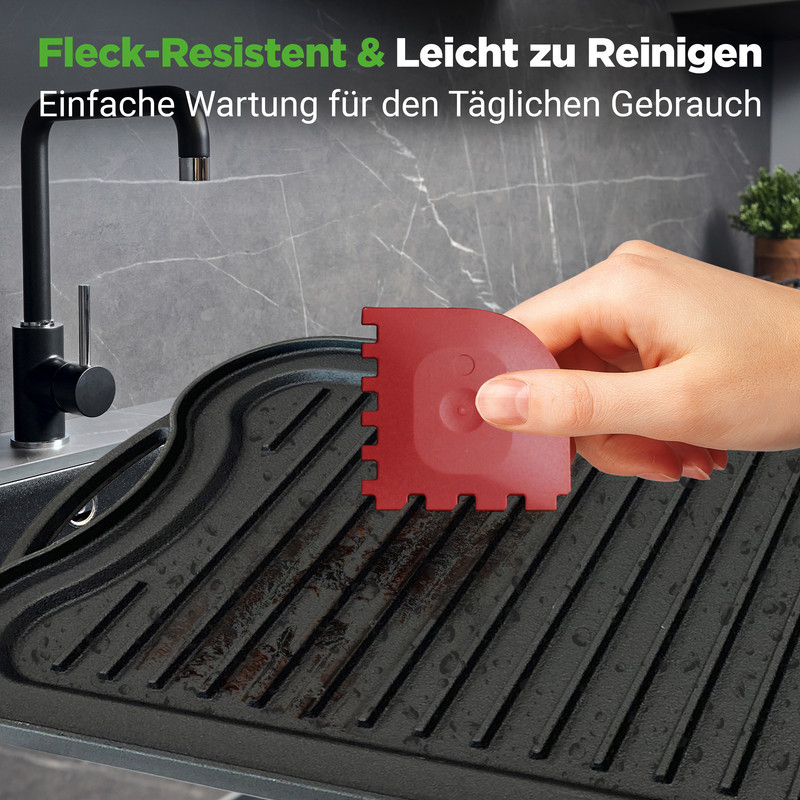 Rote Bürste reinigt Grillplatte mit Rillen neben schwarzem Wasserhahn.