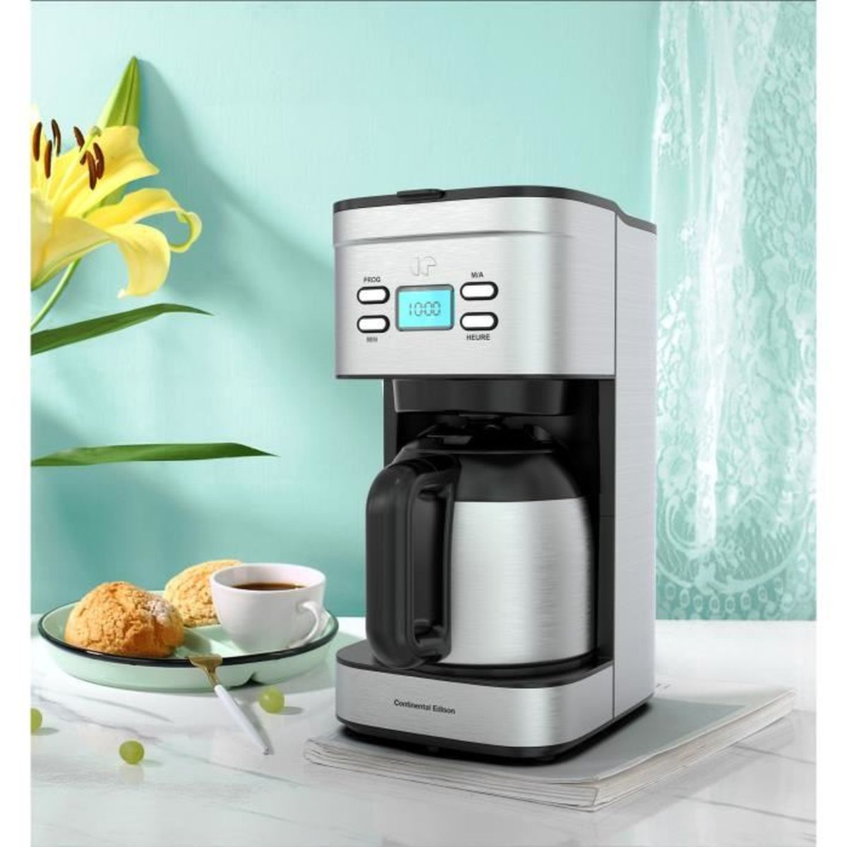 Silberne Kaffeemaschine mit Glaskaraffe, neben Gebäck und einer Tasse Kaffee.