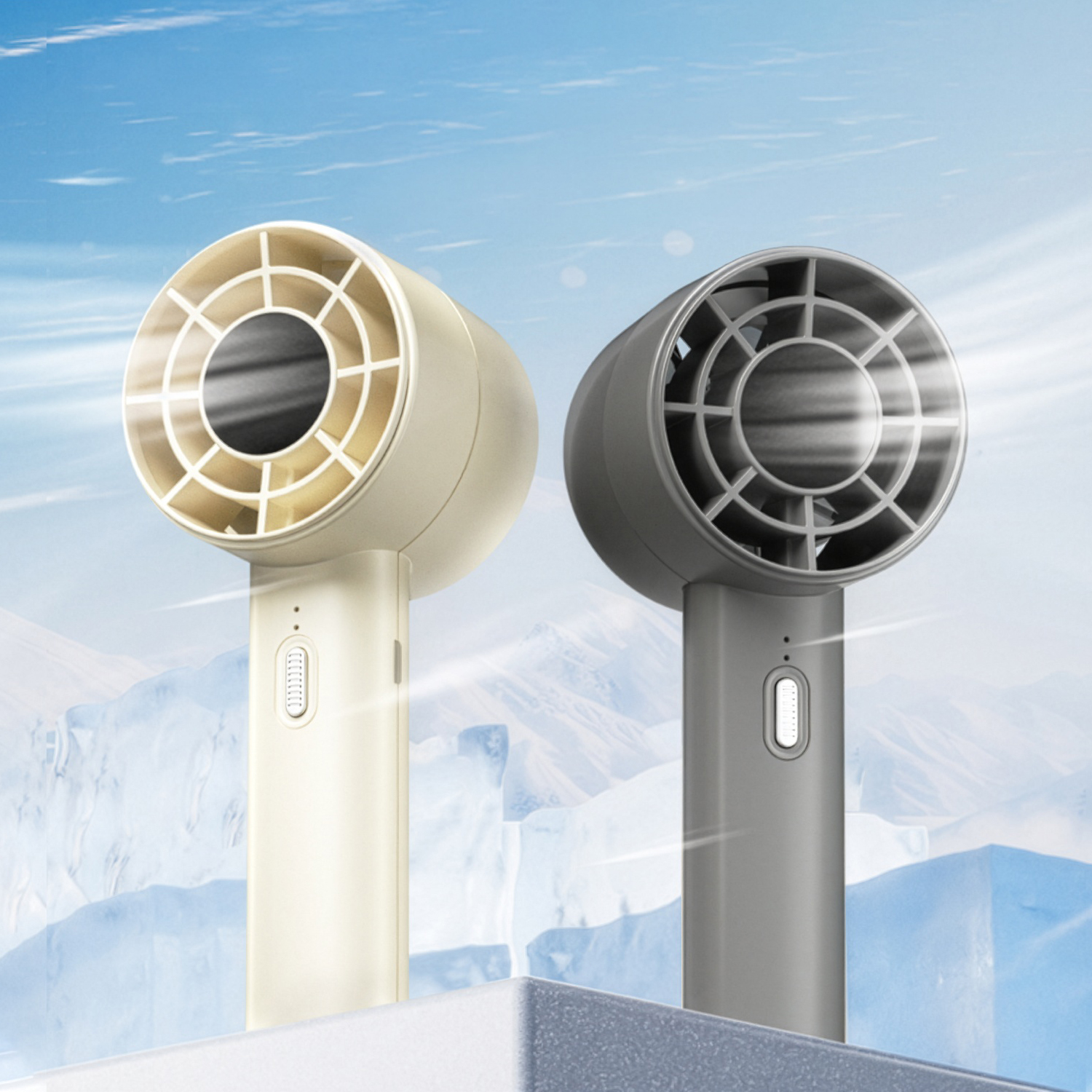 Dos ventiladores portátiles, uno beige y otro gris, frente a icebergs y cielo azul.