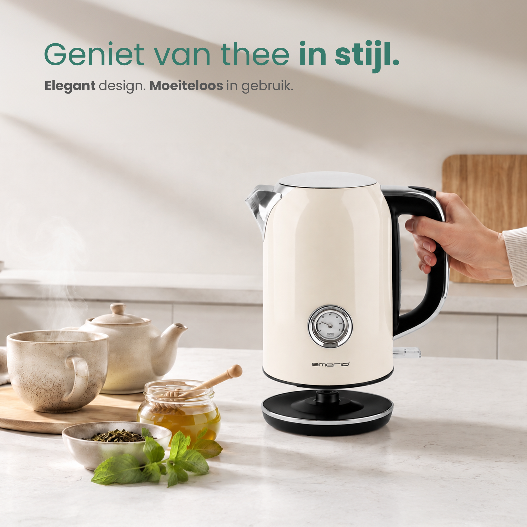 A cream-colored electric kettle with thermometer, cup, honey, and mint.
