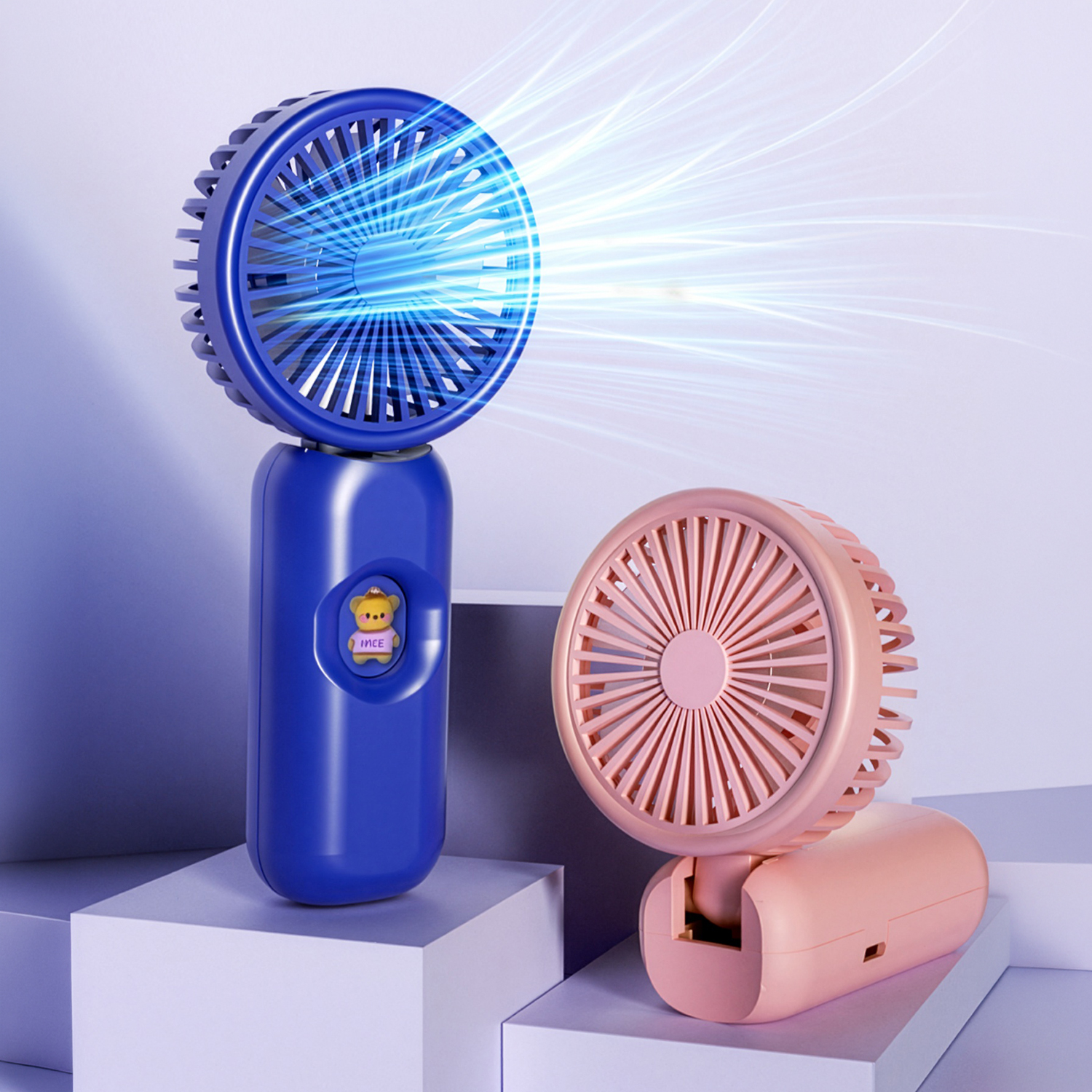Dos ventiladores portátiles, uno azul y otro rosa, sobre pedestales blancos.