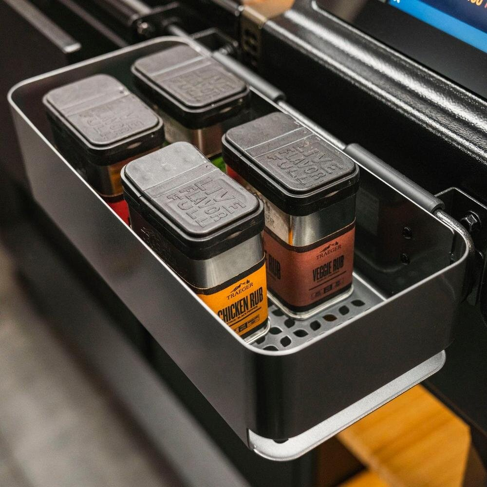 Cuatro condimentos Traeger en un caddy de metal. Visibles los condimentos de pollo y vegetal.