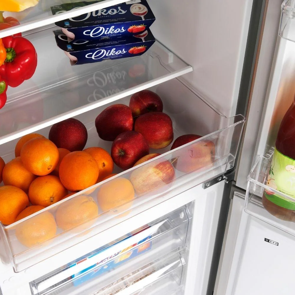 Refrigerator with apples, oranges, red bell pepper, and yogurt packs.