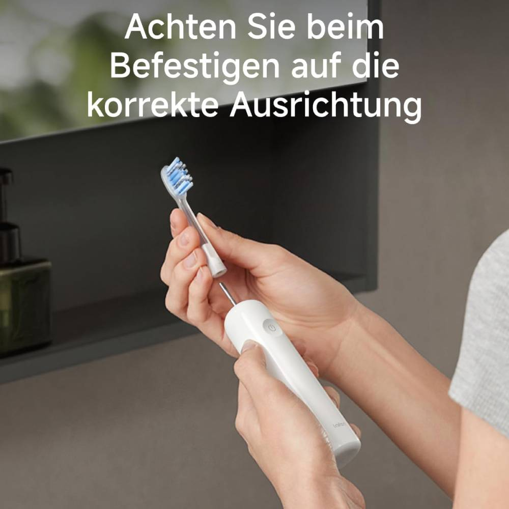 Kişi, elektrikli diş fırçasına fırça başlığı takıyor.