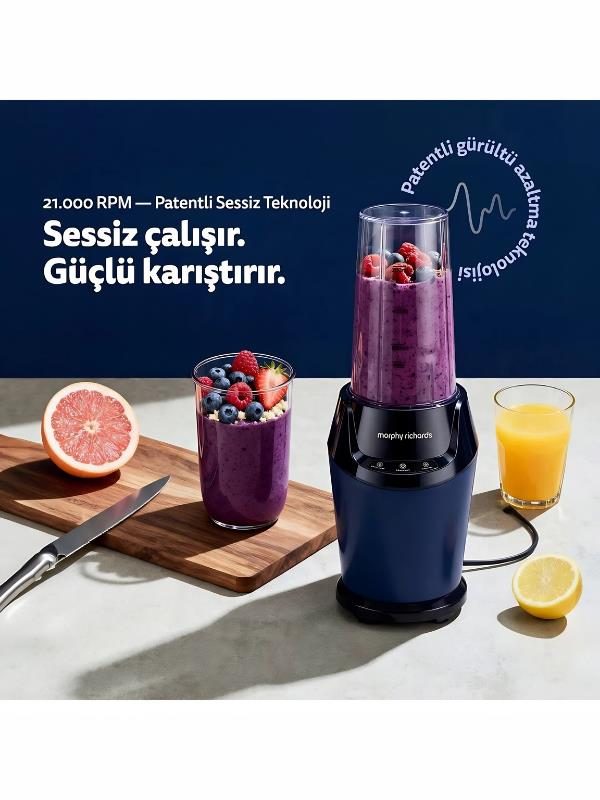 Mavi bir blender, bir bardak smoothie, greyfurt ve limon ile ahşap bir masanın yanında duruyor.