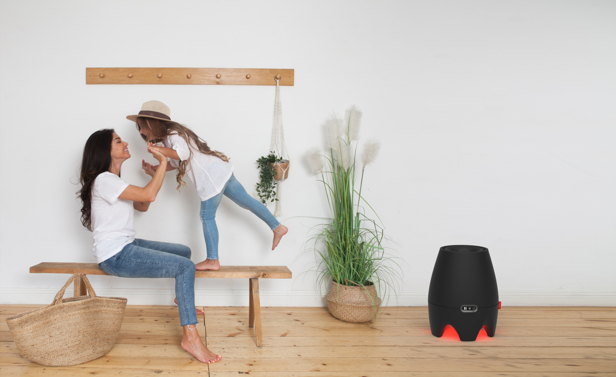 Mother and child playing on a wooden bench near an air purifier.
