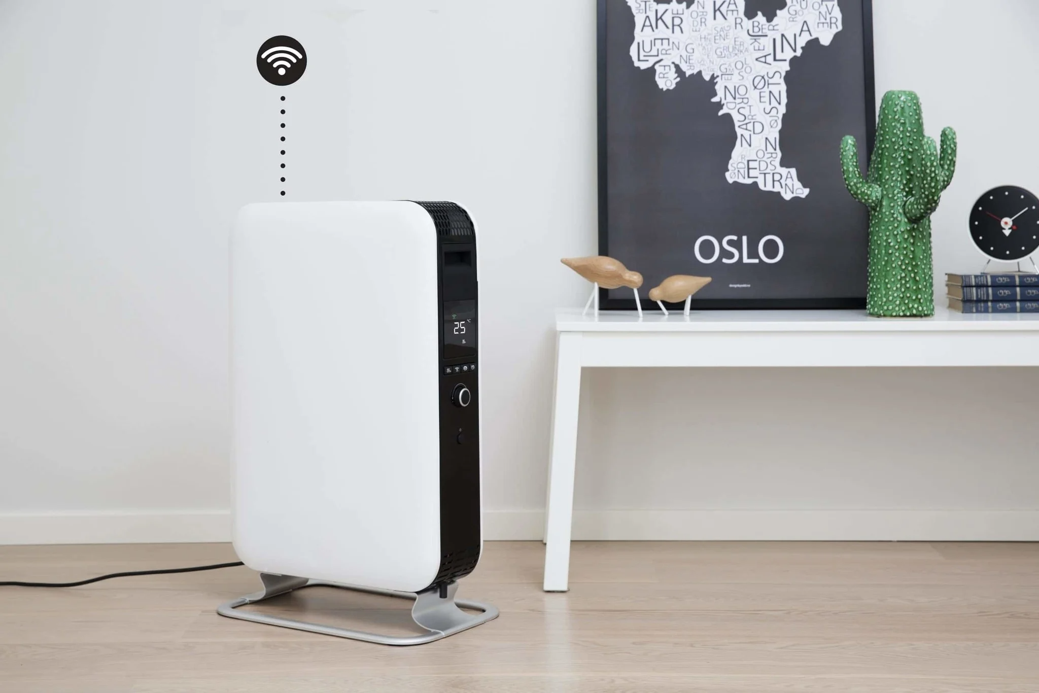 Un radiador blanco con símbolo WiFi está sobre suelo de madera junto a una mesa.