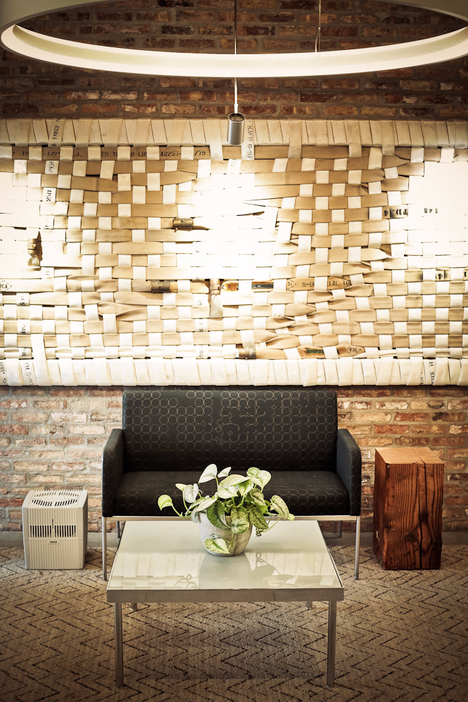 Dark gray patterned sofa, glass coffee table with plant, wooden cube, white air purifier.