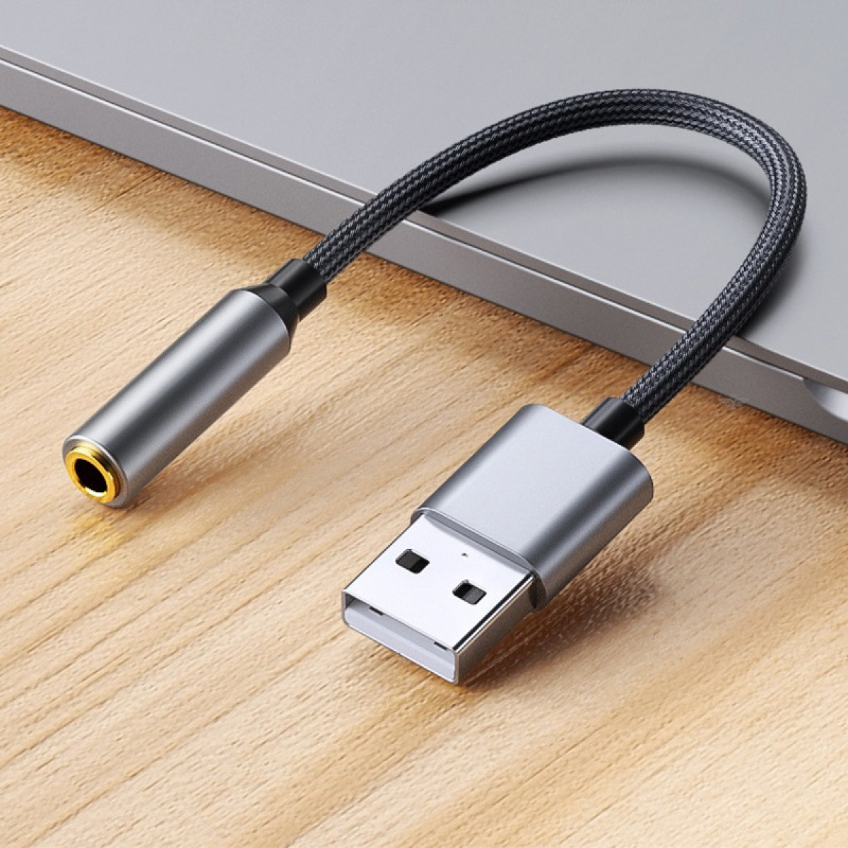 Un cavo adattatore audio da USB-C a 3,5 mm argentato con cavo intrecciato.