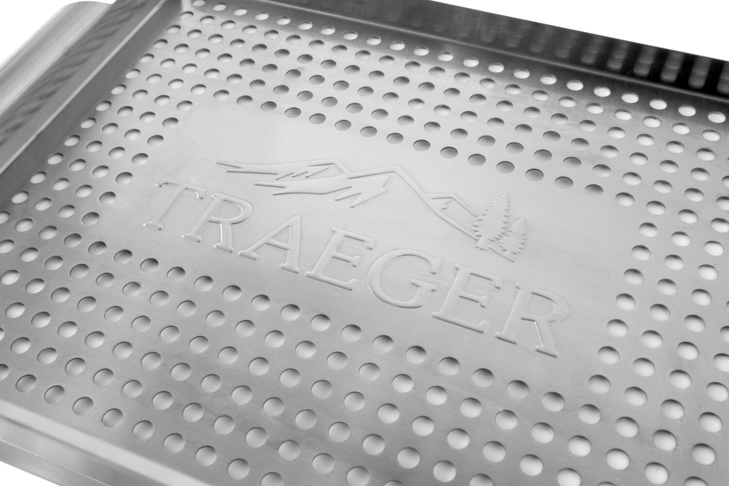 Una cesta de parrilla de metal plateada con logo Traeger, montañas y árboles.