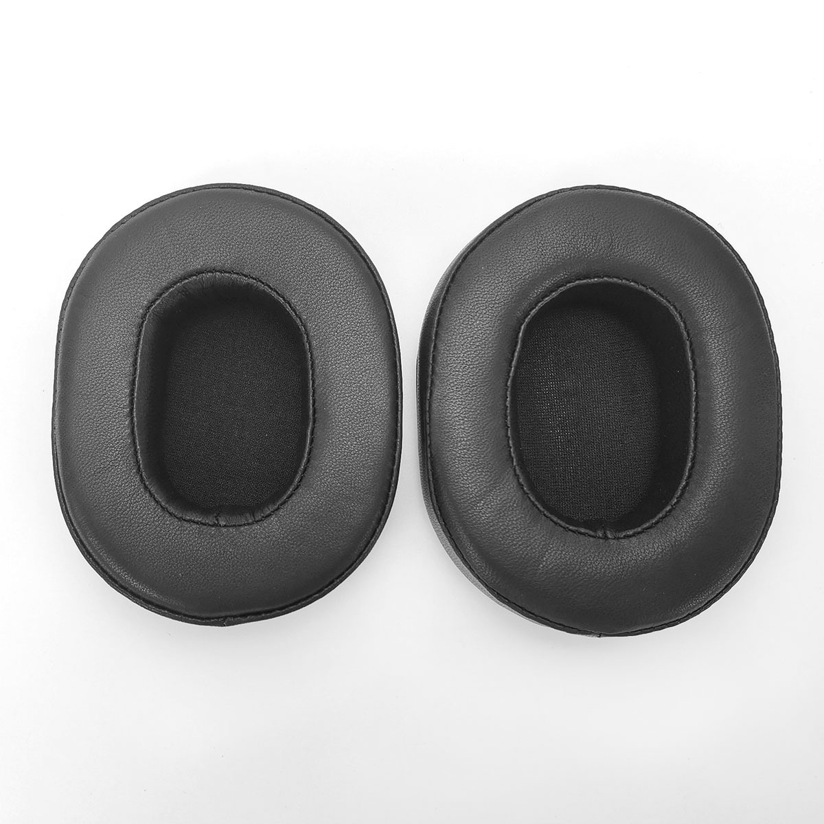 Two black faux leather headphone ear pads on a white background.