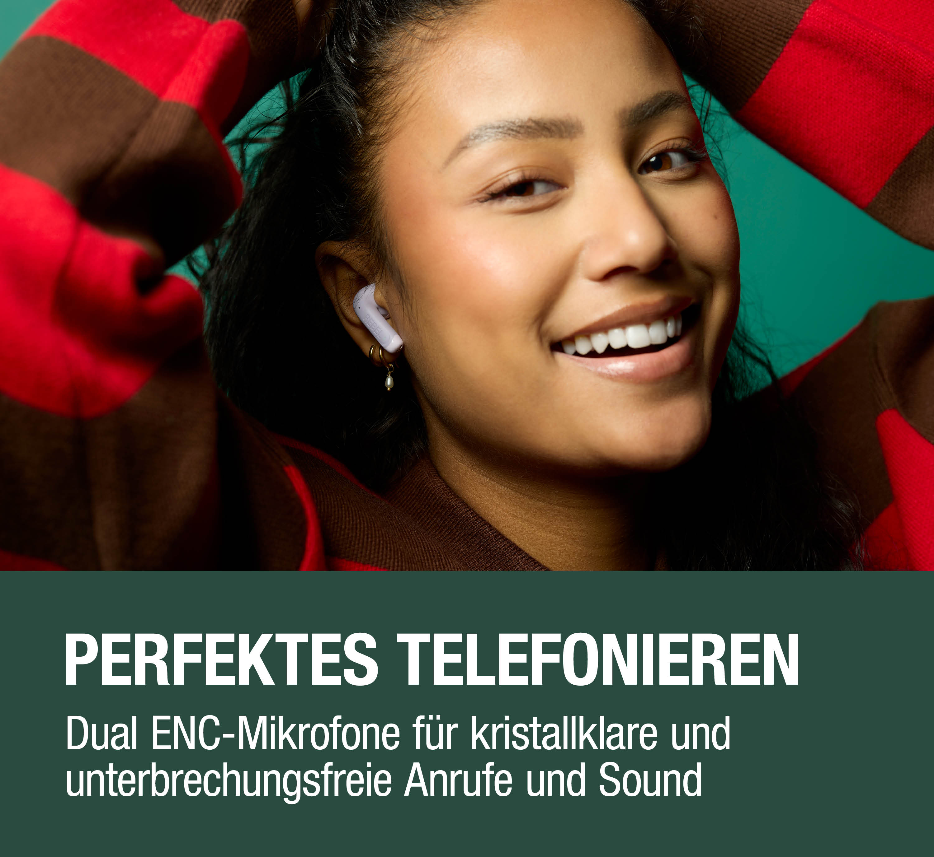 Lächelnde Frau mit Kopfhörer im Ohr und rotbraun gestreiftem Pullover.