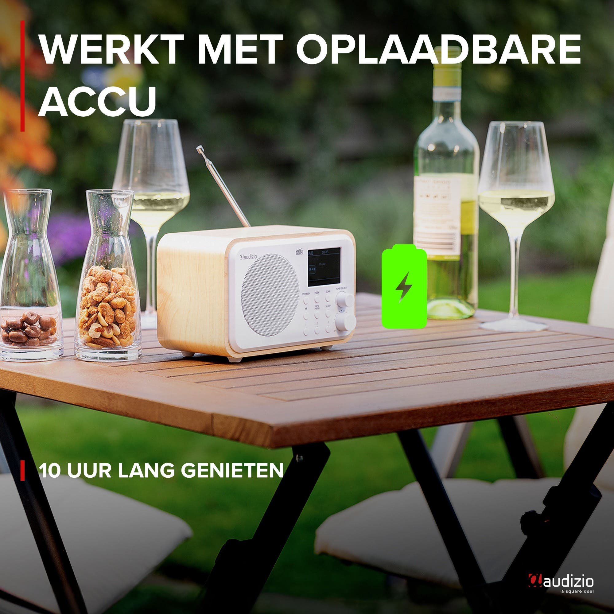 Una radio de madera, vino y copas en una mesa exterior.