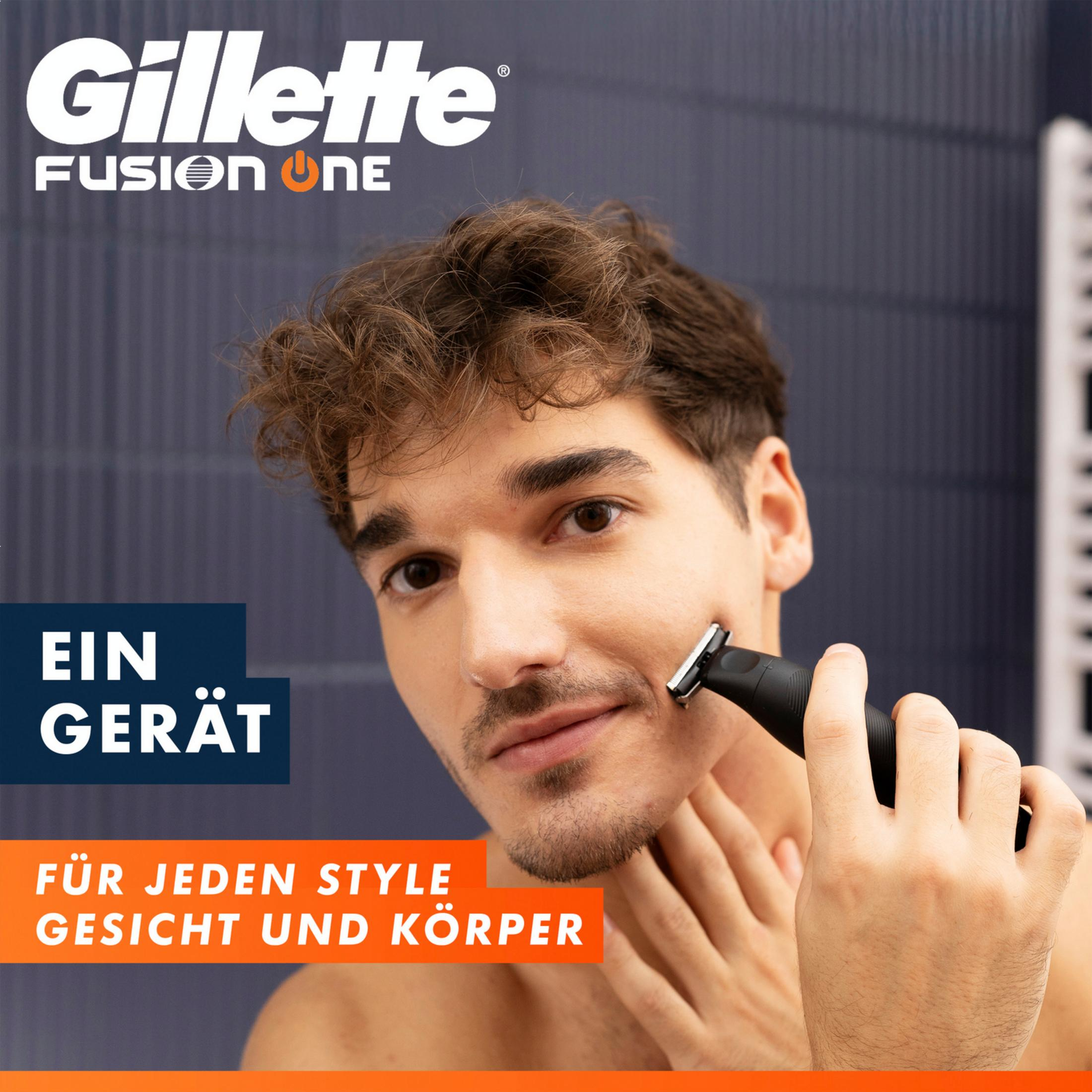 Uomo si rade con dispositivo Gillette Fusion 5. Sfondo blu scuro.