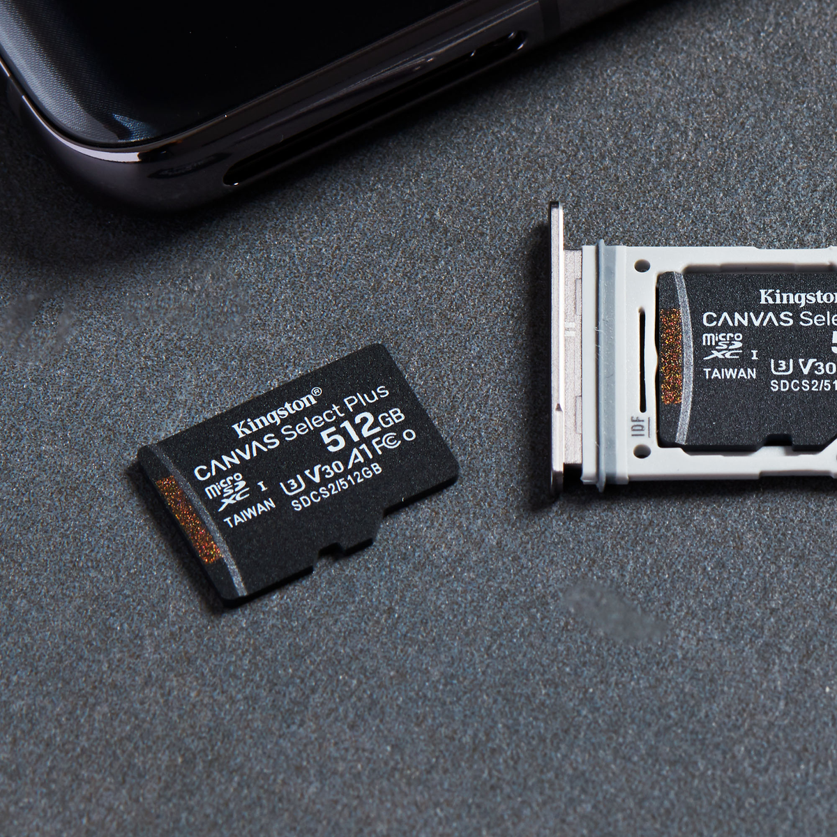 Dos tarjetas Kingston MicroSD, una de 512 GB, junto a un smartphone.