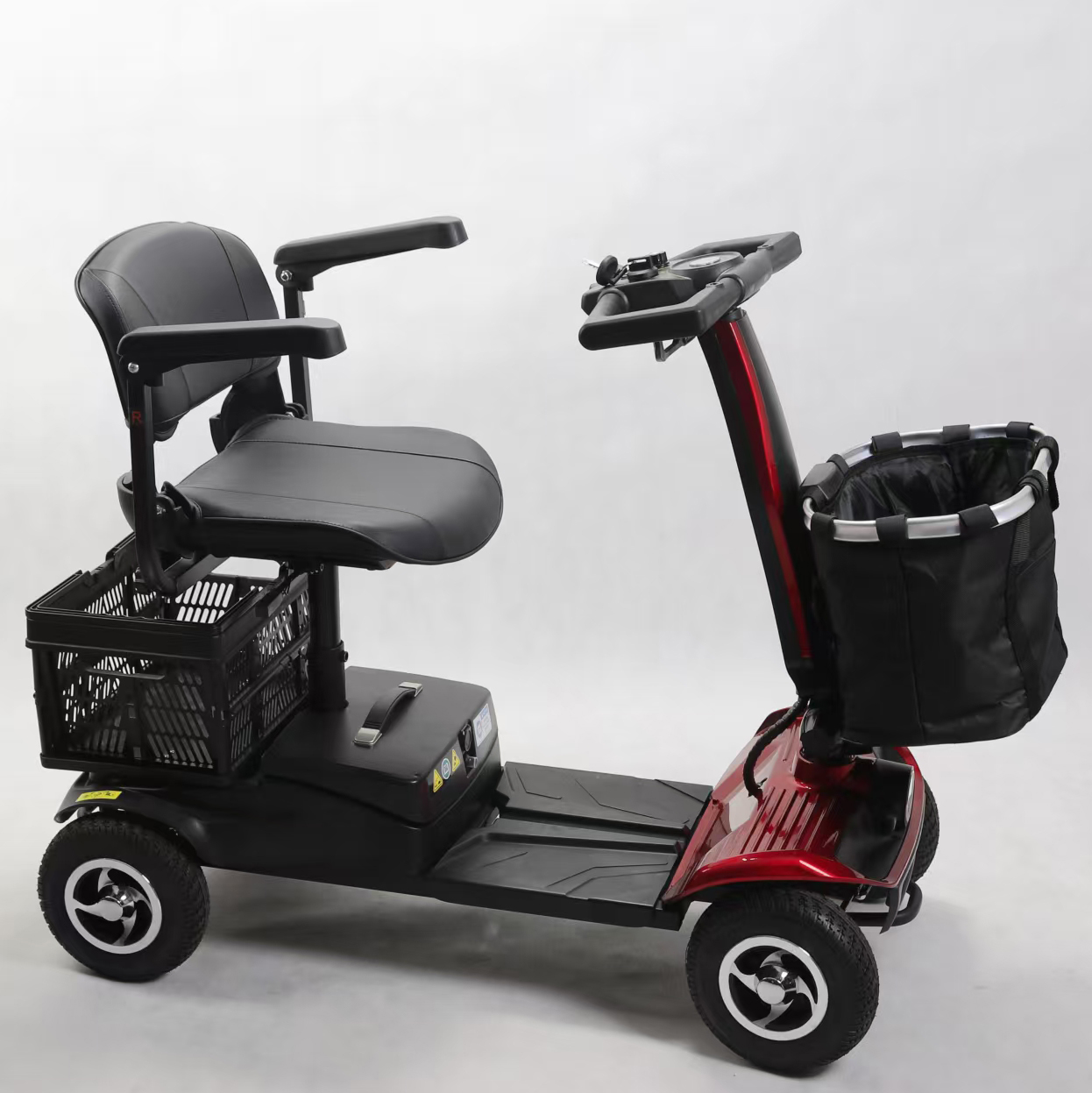 Uno scooter per la mobilità rosso e nero con sedile, manubrio e cesti.