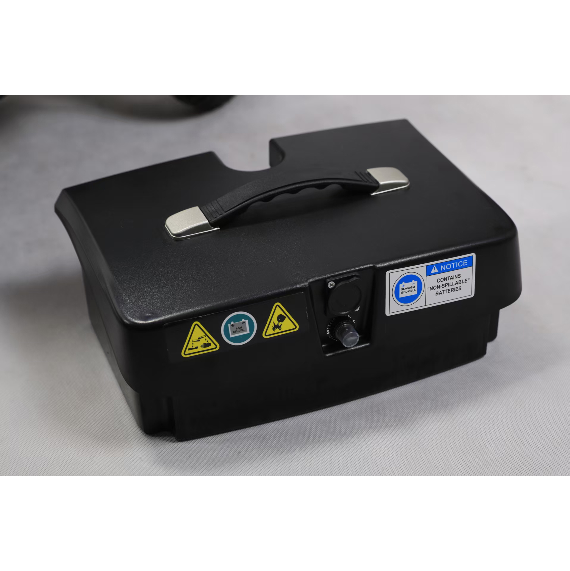 Batteria nera con maniglia ed etichette di avvertenza. Contiene batterie "non spillabili".