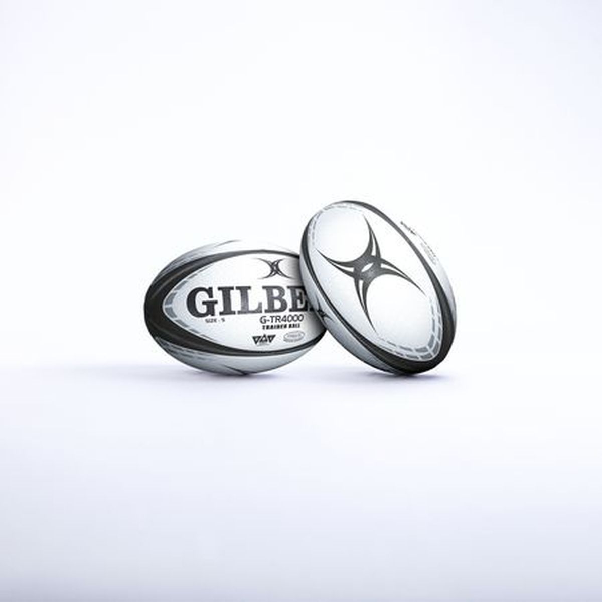Due palloni da rugby Gilbert bianchi con finiture e loghi neri su sfondo bianco.