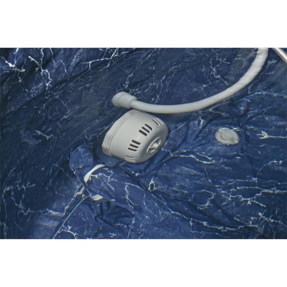 Un filtro dell'acqua grigio con tubi su uno sfondo blu scuro marmorizzato.