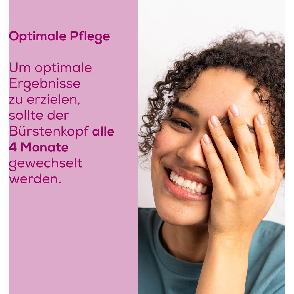 Frau mit lockigen Haaren lächelt und bedeckt ihr Auge. Text auf Deutsch.