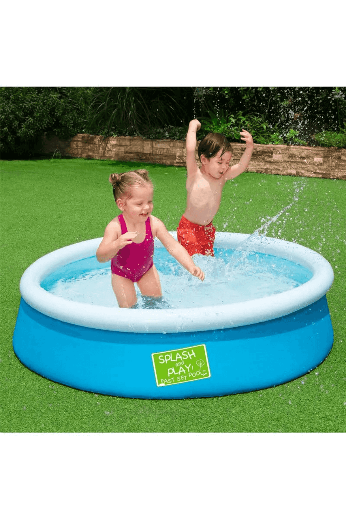 Dos niños chapotean en una piscina hinchable azul sobre césped verde.